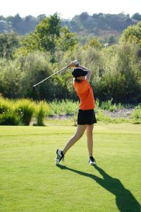 Golf pour les femmes Un adolescent faisant un swing au Golf